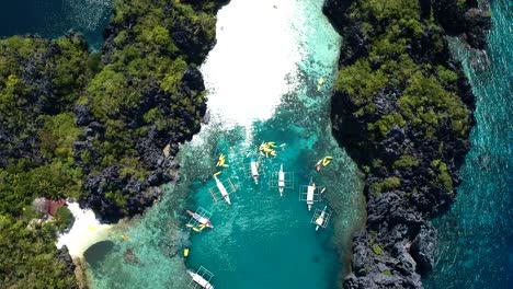 Aéreo-De-Arriba-Hacia-Abajo-De-Barcos-Fuera-De-La-Gran-Laguna,-Pequeña-Laguna,-El-Nido,-Palawan,-Filipinas