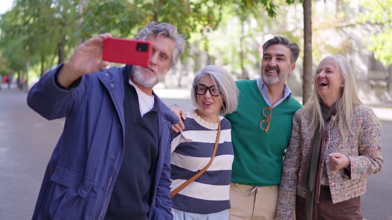 Amigos idosos felizes tirando uma selfie com um smartphone ao ar livre