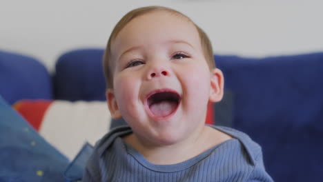 Baby-smiling-and-laughing-playing-with-a-blue-silk-with-yellow-stars-in-slow-motion