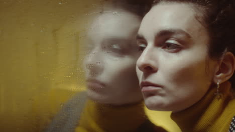woman leaning against wet mirror