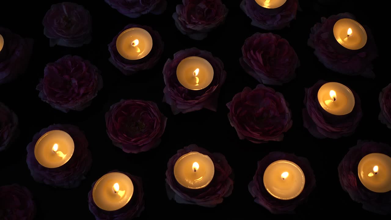 розы и свечи на черном фоне.