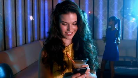 Smiling-woman-with-cocktail-drink-typing-a-message