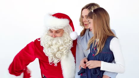 niña pequeña diciéndole a papá noel lo que quiere para navidad con su madre