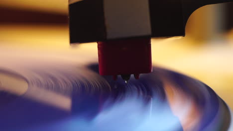 gramophone needle and spinning blue vinyl record, macro close up