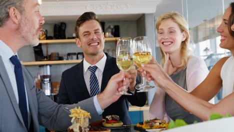 Businessmen-and-colleagues-toasting-glasses-of-wine-while-having-meal