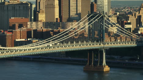 aerial view of the manhattan bridge at sunrise. shot along the east river in new york city.