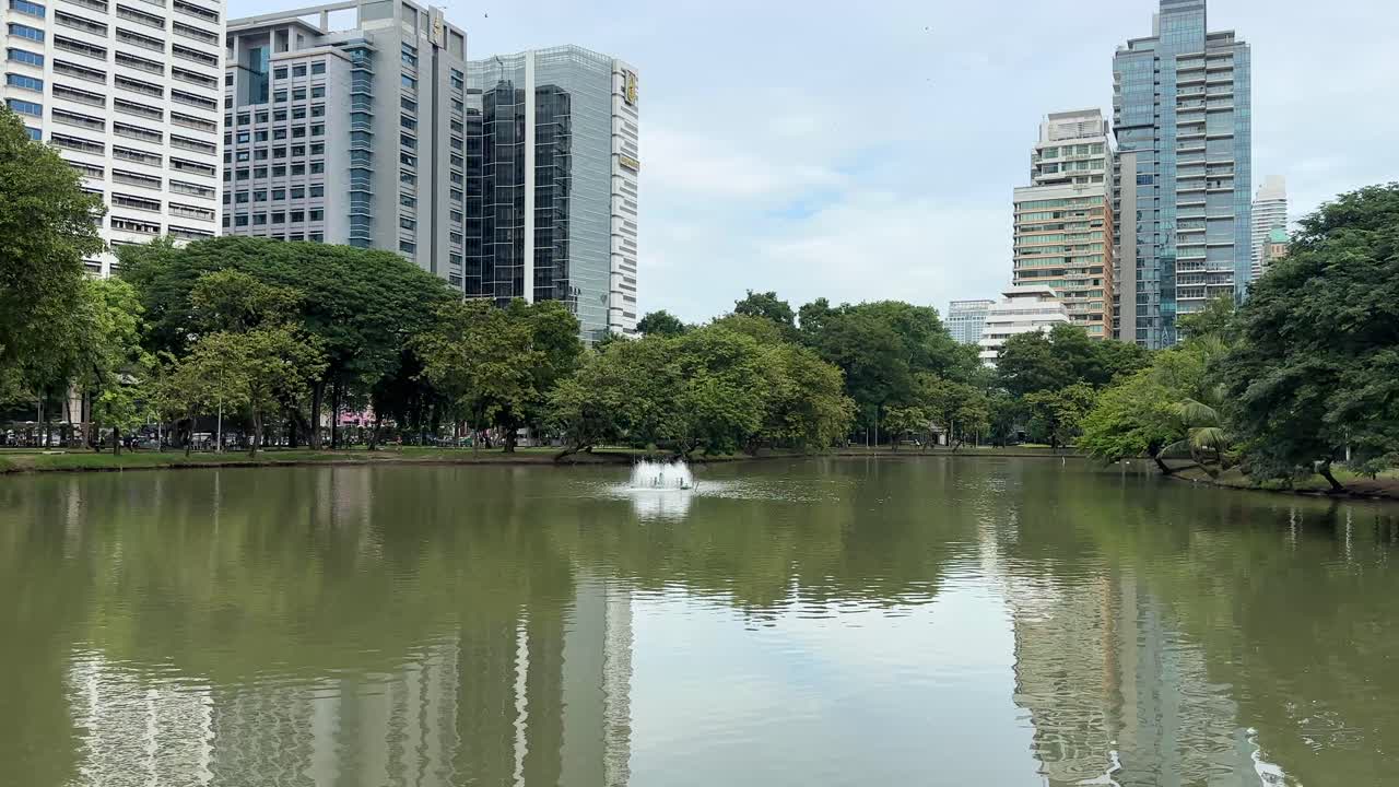 Lumphini Park Bangkok Thailand – Bypark med sø og Bangkoks skyskraber-skyline, urbant naturlandskab