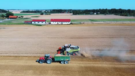 toma aérea de una cosechadora cargando granos de maíz en un remolque de tractor-4