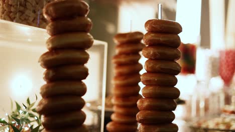 tower stack of sweet delicious glazed ring donuts at a wedding reception buffet, closeup dolly out shot