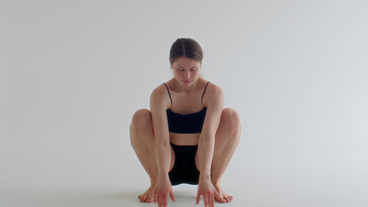 Female Yoga Practitioner Performing Firefly Pose in Studio