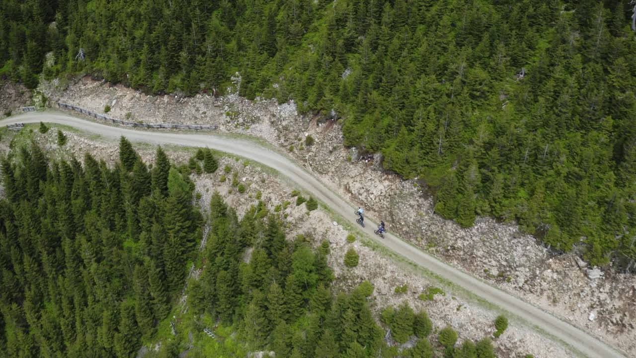 Cyclist group cycling on road in mountains in Moravia, drone shot
