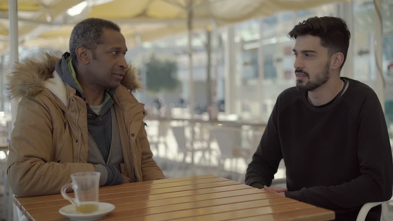 Multiethnic friends sitting and talking in cafe