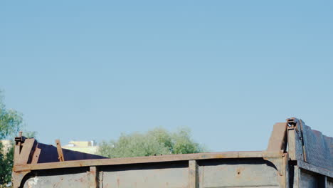 an excavator pours soil into the truck body with its bucket earthworks at a construction site