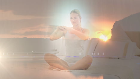 animation of landscape over caucasian woman practicing yoga and meditating