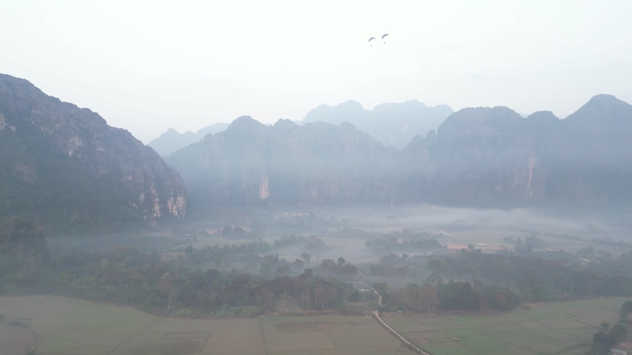 drone shot of fog during misty morning in Vang Vieng, the adventure capital of Laos
