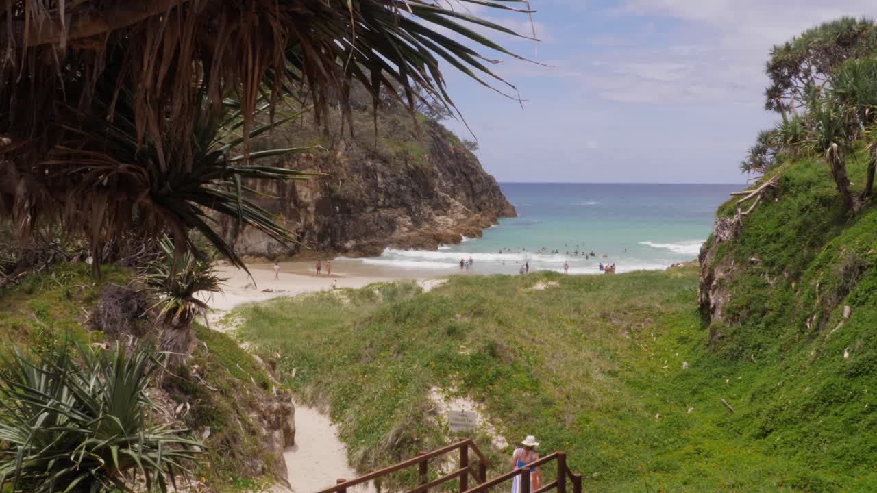 mujer turista caminando en el paseo marítimo con la playa de south gorge en la distancia en el punto de observación, north stradbroke island, queensland, australia