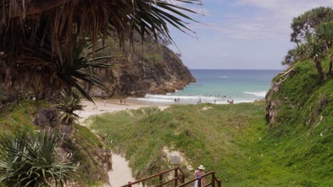 Mujer-Turista-Caminando-En-El-Paseo-Marítimo-Con-La-Playa-De-South-Gorge-En-La-Distancia-En-El-Punto-De-Observación,-North-Stradbroke-Island,-Queensland,-Australia