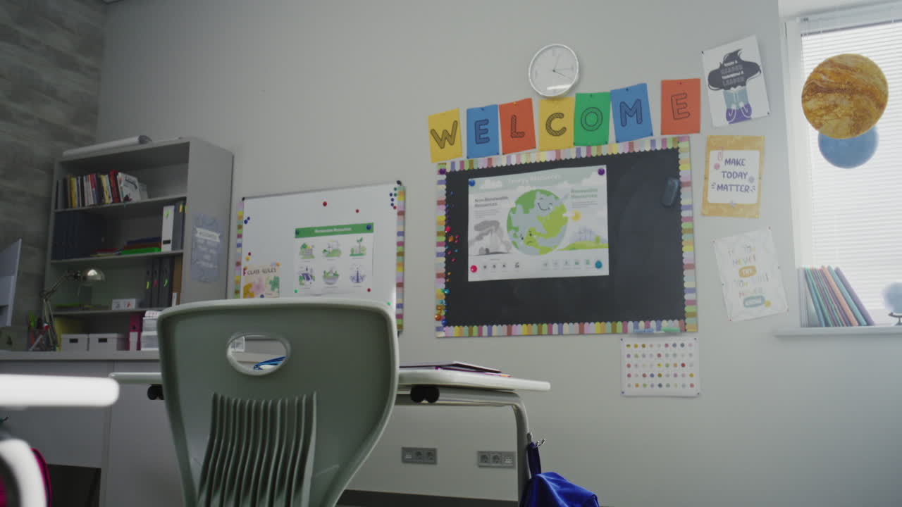 School supplies on wooden desk in empty classroom interior at elementary school