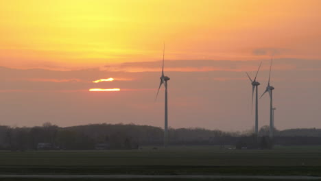 wind turbines filmed in the fields at sunset