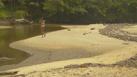 Sexy-Model-Läuft-Auf-Dem-Sand,-Bevor-Es-In-Den-Kalten-Fluss-Eintritt