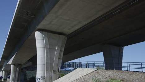 Wide-shot-of-Mountain-biker-cycling-under-concrete-bridge
