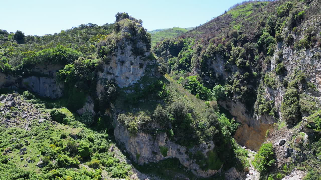 Aerial drone footage of the Catafulcro Waterfall, Sicily: flowing cascade, rocky cliffs and lush green surroundings. Ideal for nature, travel and scenic landscape projects