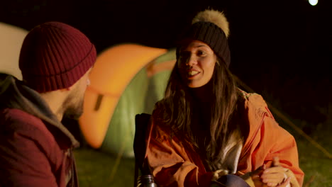 close friends around camp fire in a cold night in mountains