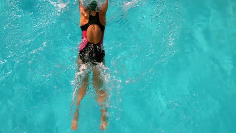 Fit-woman-swimming-in-the-outdoor-pool-overhead-