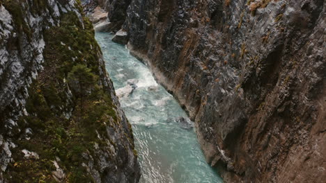 flying along water stream inside wet rocky ravine