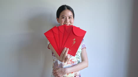 beautiful asian woman wear chinese traditional dress with red envelope or red packet