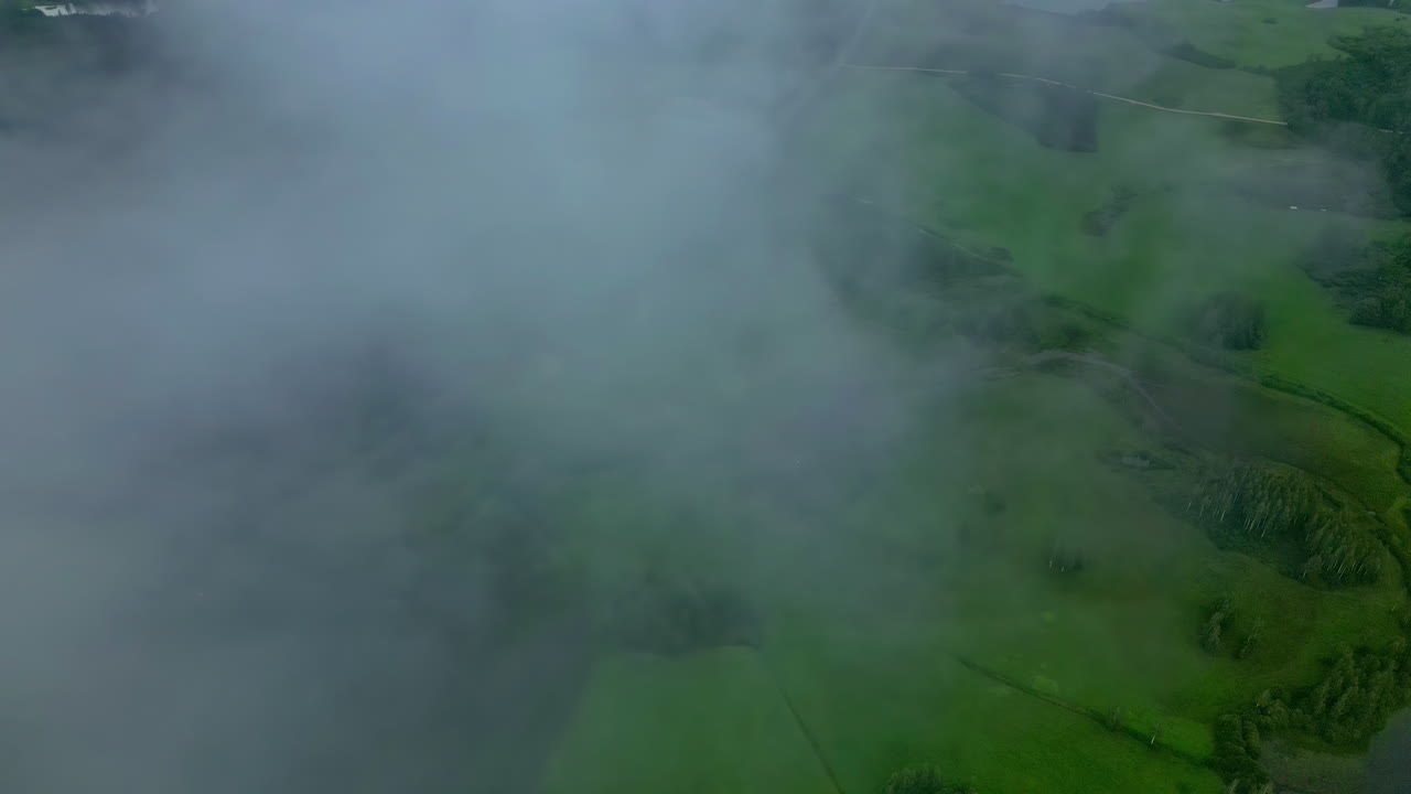 초록색 시골 풍경 위에 몇 개의 희미한 구름