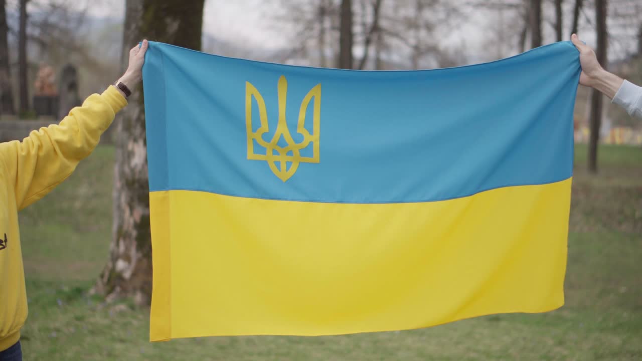 소녀와 소년은 우크라이나 발을 들고 걸어가고 있습니다. 공감의 상징입니다. 소녀의 스웨터에 새겨진 글자: "당신의 의견은 중요합니다."