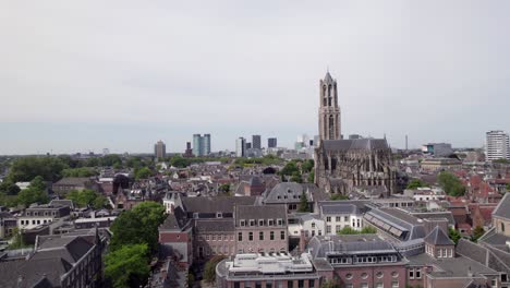 aerial of gothic cathedral nave and de dom church tower architecture among historic buildings in utrecht city center. dutch holland religious tourist destination seen from above.