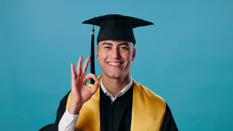 a graduate smiling and giving an ok sign