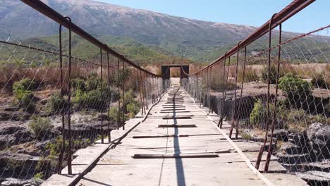 Hölzerne-Und-Wackelige-Hängebrücke-über-Den-Fluss-Vjosa,-Albanien---Fly-Trough