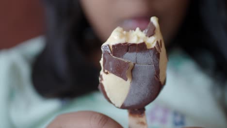 girl eating a chocolate and vanilla ice cream popsicle