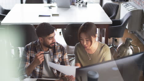 Young-Asian-man-and-Asian-woman-review-business-documents-in-an-office-setting