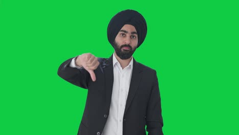 disappointed sikh indian businessman showing thumbs down green screen