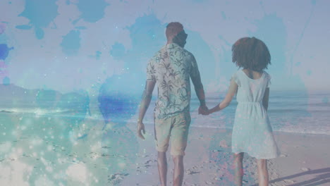 walking on beach, couple holding hands with animation of colorful paint splashes