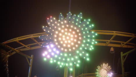 wideshot spiral fairground attraction with bright lights