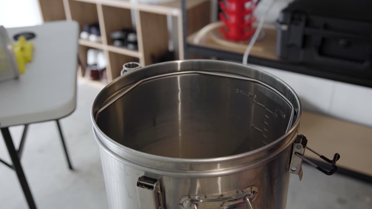 la inserción de la pantalla de metal de fondo falso y el tuner de puré en la tetera de cerveza de metal, ángulo alto de cerca