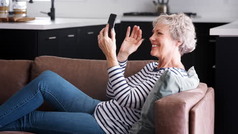 Videollamada-De-Mujer-Mayor-Con-Teléfono-Inteligente-En-El-Sofá-En-Casa