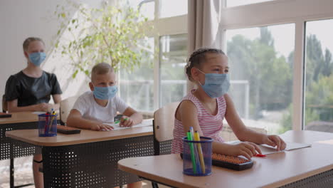 Levante-La-Mano-Para-Responder-La-Pregunta-Del-Profesor.-Grupo-Multiétnico-De-Niños-Con-Máscaras-En-La-Escuela-Durante-La-Pandemia-De-Covid-19.