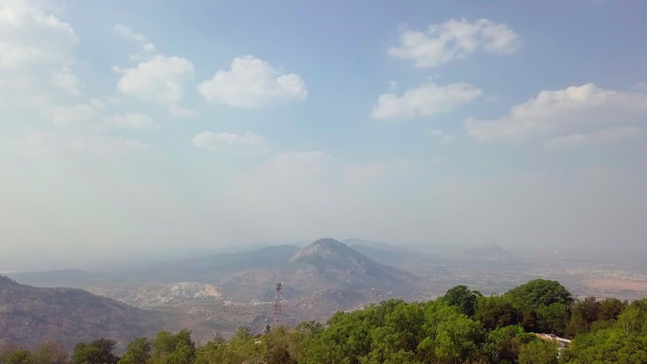 Moving aerial shot of Nandi Hills surrounded with clouds and fog in Karnataka, India. 4k. Tourist destination.