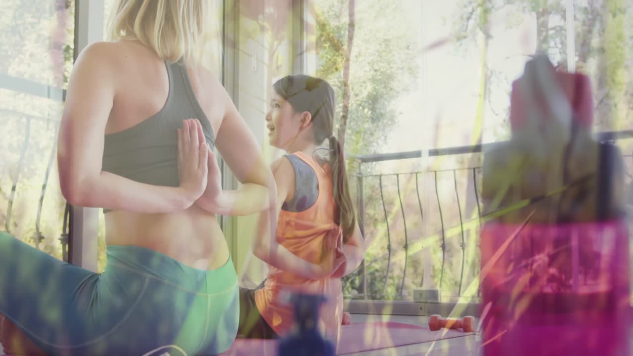 animación de hierba moviéndose sobre feliz mujer caucásica con su hija haciendo yoga