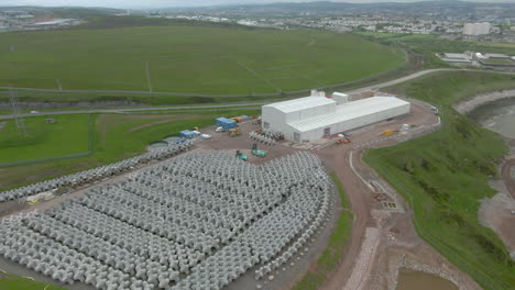 una vista aérea del exterior de una planta de hormigón en nigg bay, aberdeenshire, que muestra tetrápodos de hormigón alineados almacenados en el exterior.