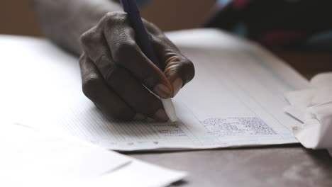 Teacher-in-Sierra-Leone-looking-over-grades