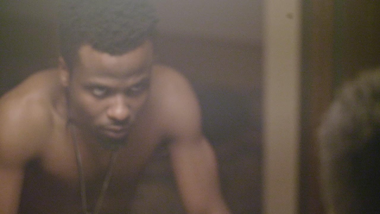 hombre afroamericano enojado mirando su reflejo en un espejo