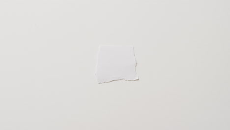 video of close up of torn piece of paper with copy space on white background