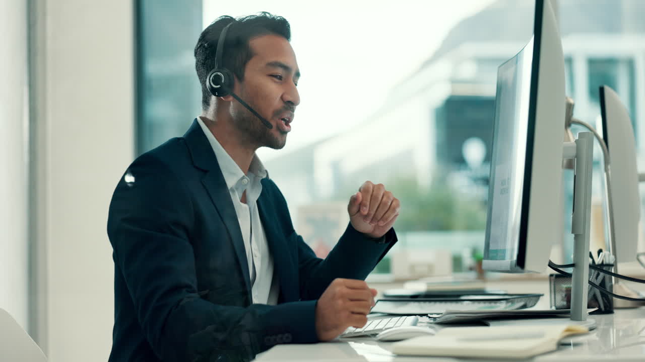Man in Headset Talking and Smiling at Computer in Office